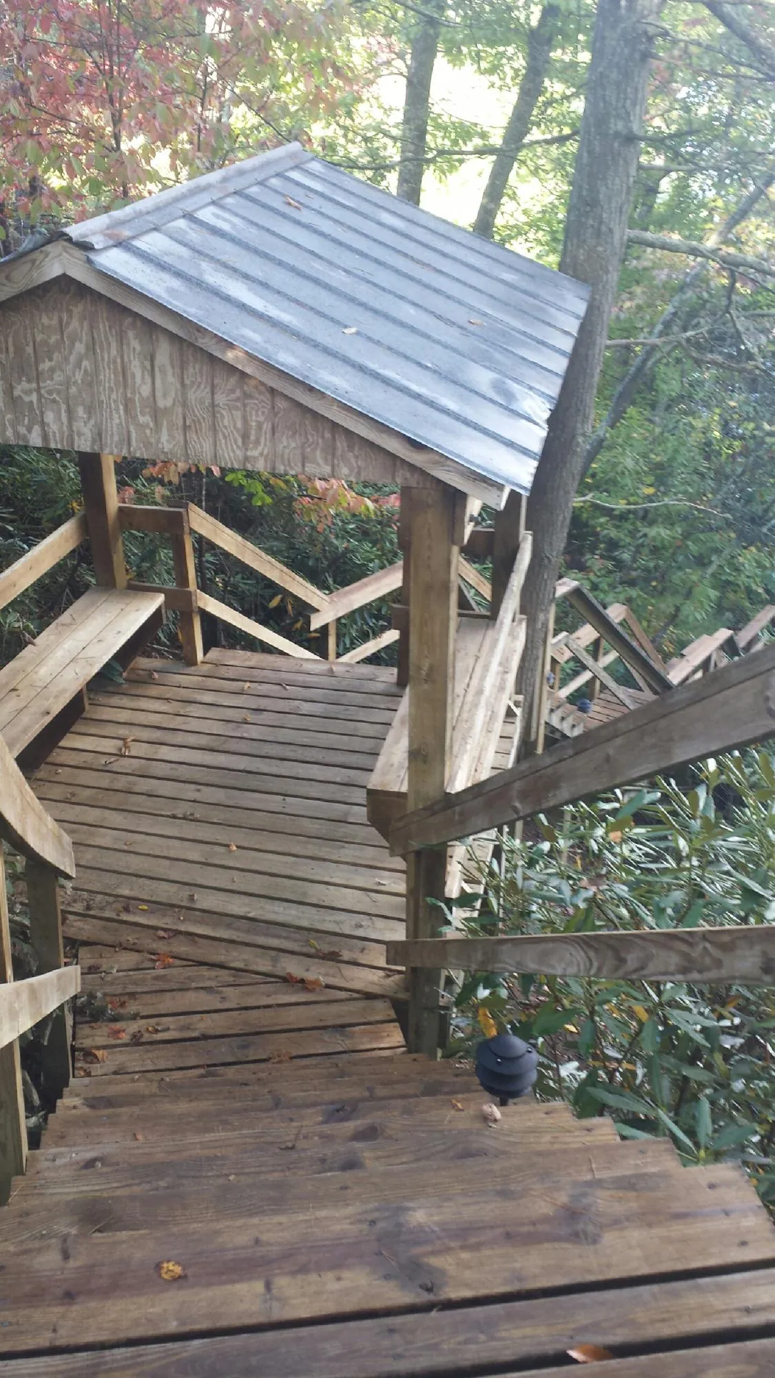 Metal roofed shelter over wooden steps on a wooded walkway — Skylight Repair & Installation work by our crew in Charlestown