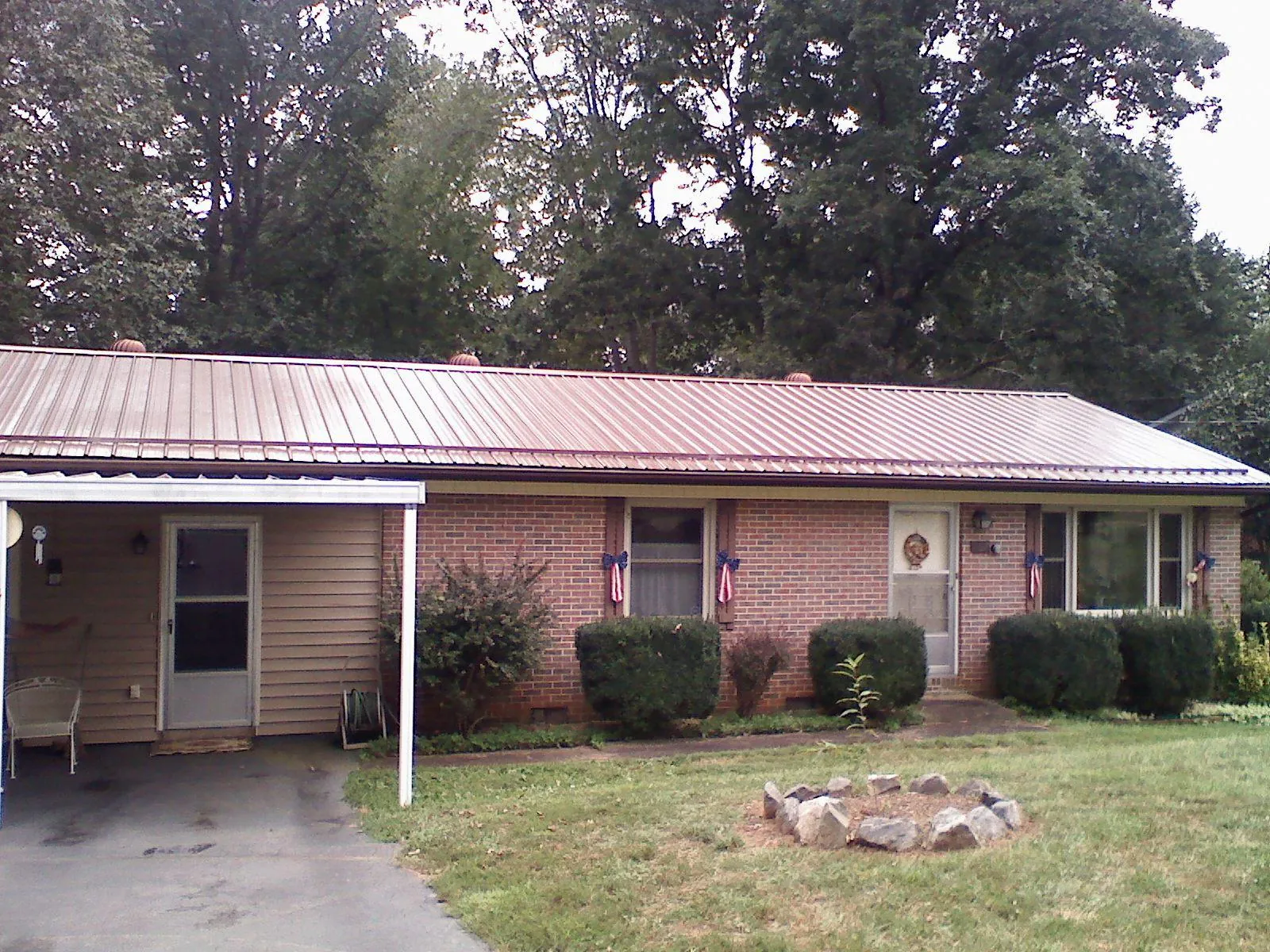 Bronze metal roof and carport on a brick ranch home — Roof Repair work by our crew in Charlestown